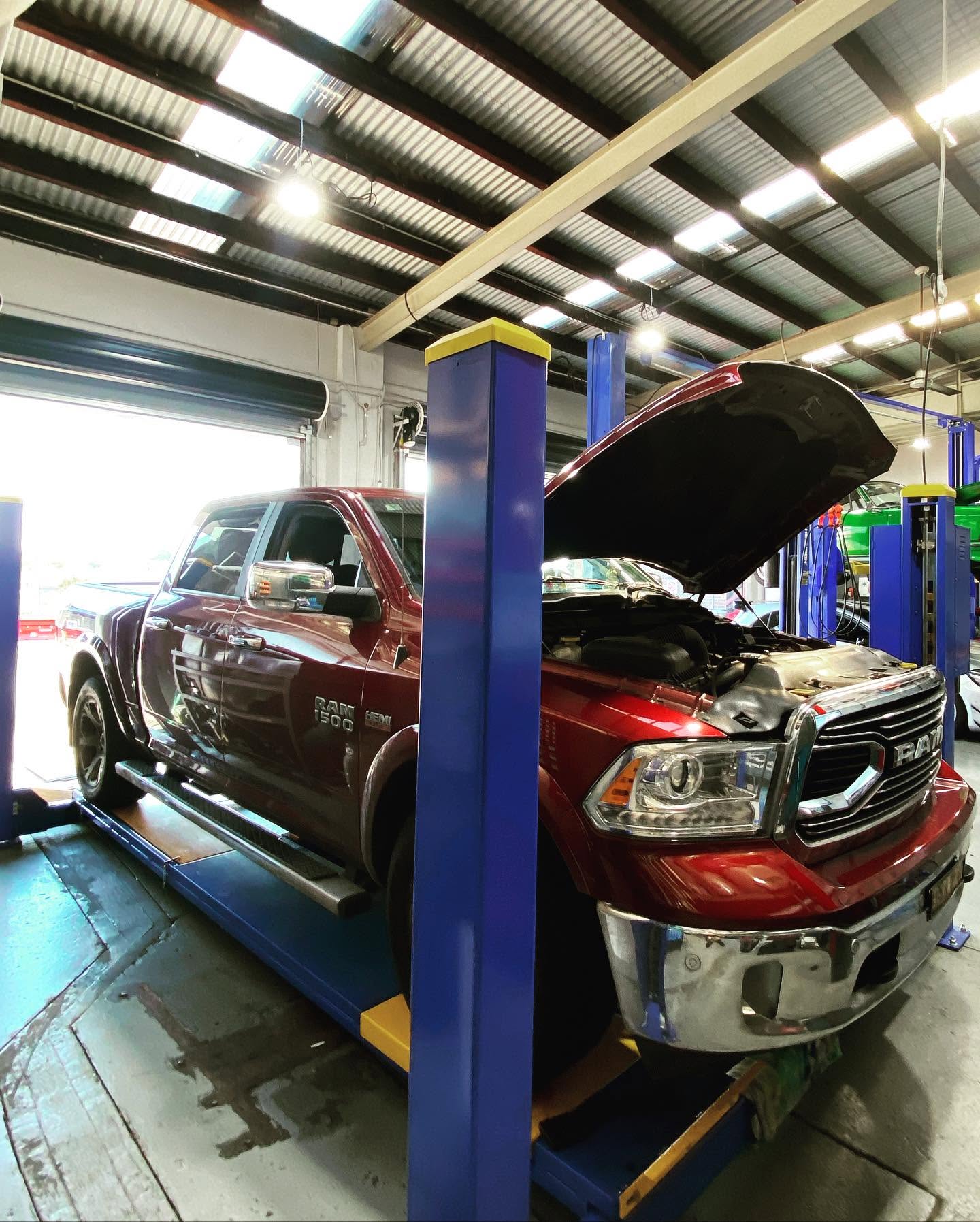 Pickup truck engine bay opened on a workshop hoist for engine repairs