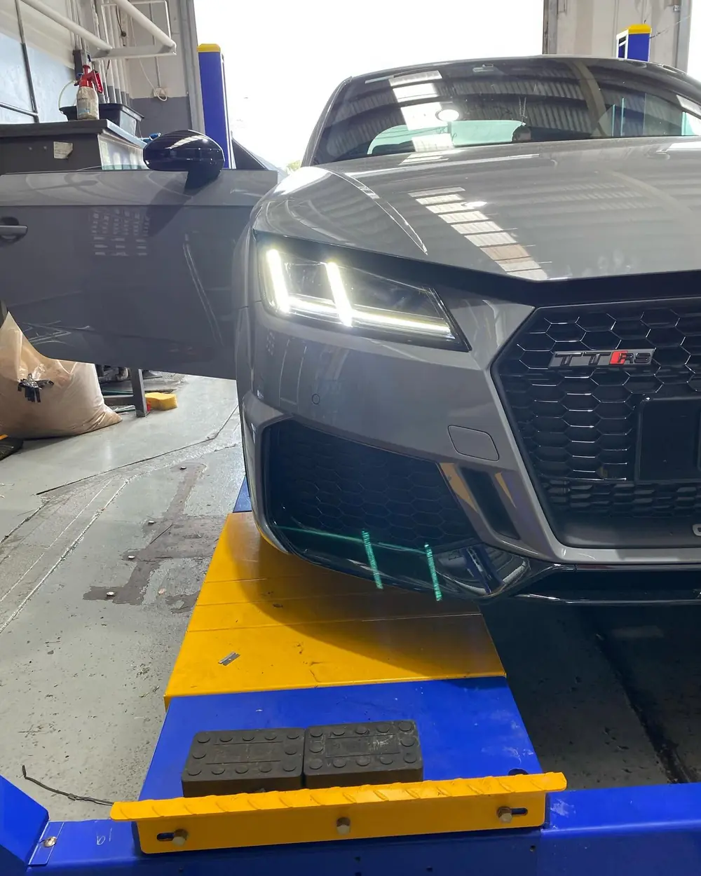 Grey car on a workshop wheel alignment platform